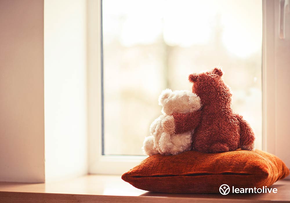 A big teddy bear hugging a smaller teddy bear